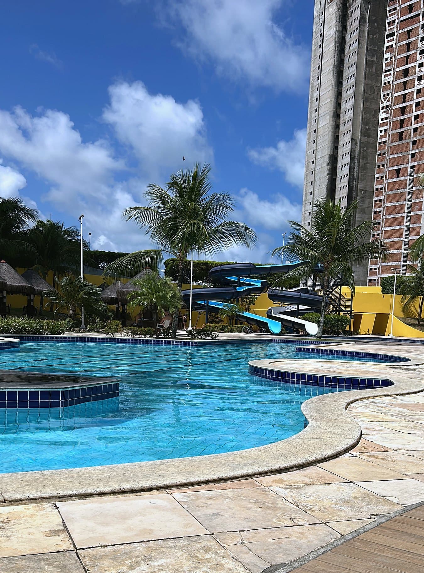 Piscina principal do Corais de Ponta Negra, com toboágua e coqueiros